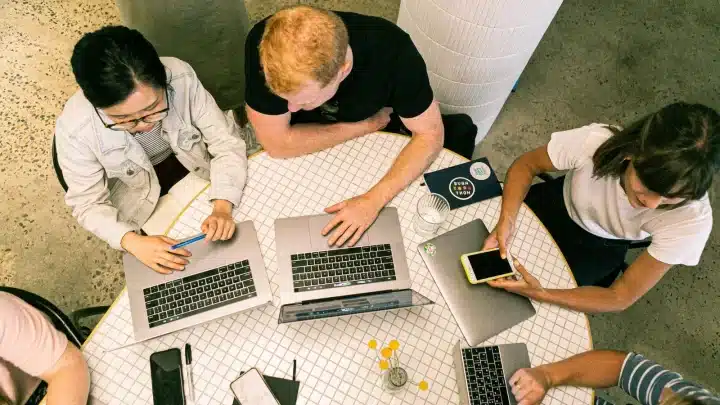 An agency team plans the four weeks of a qualified-lead sprint on their laptops